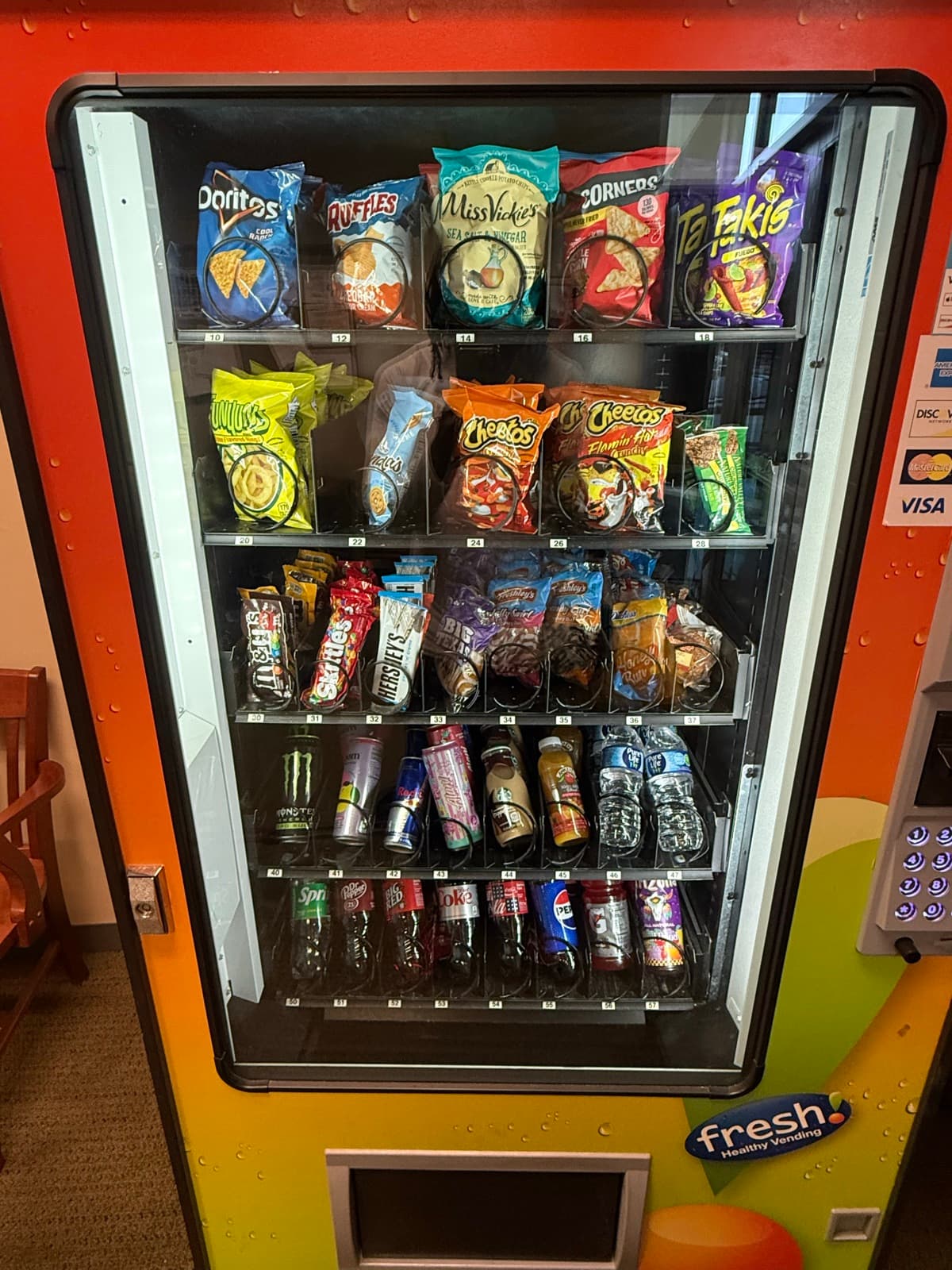 Snack vending machine stocked with chips, candy and drinks